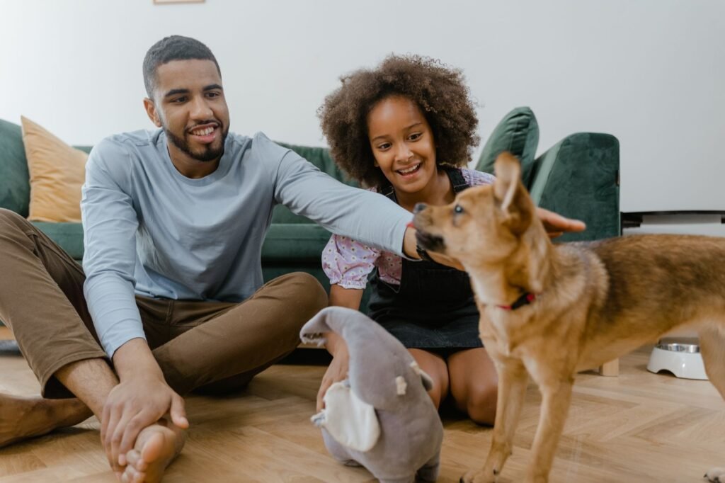 Man and girl enjoying quality time with their dog indoors, promoting family bonding.